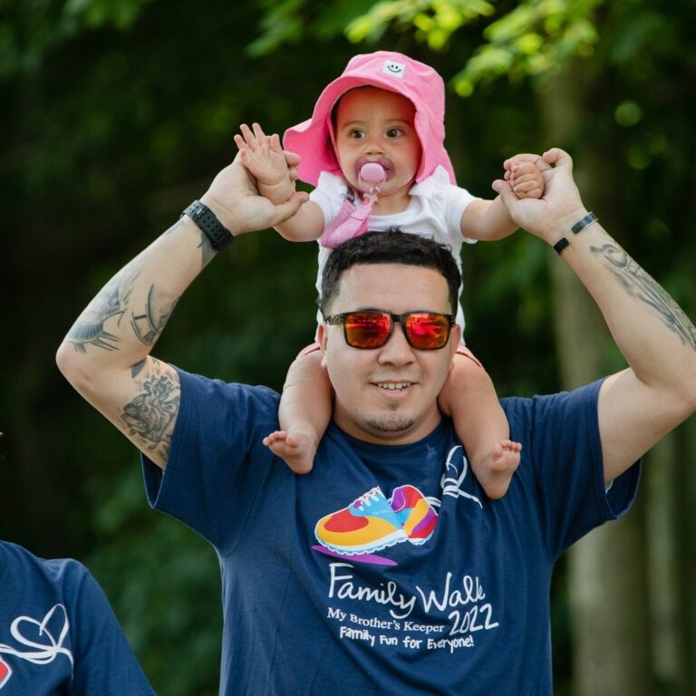 Man walking with baby on shoulders