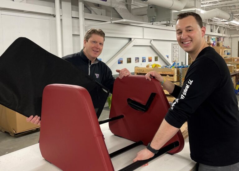 My Brother's Keepers members smiling with a piece of furniture