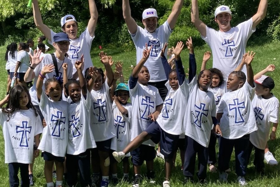 Teen volunteers with children at park.