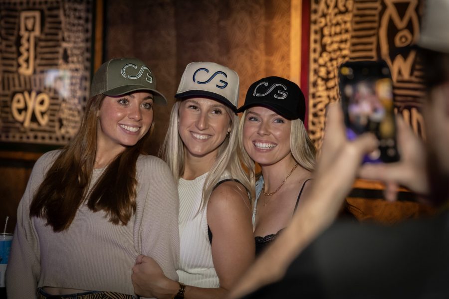 Three women in CCG hats having their picture taken